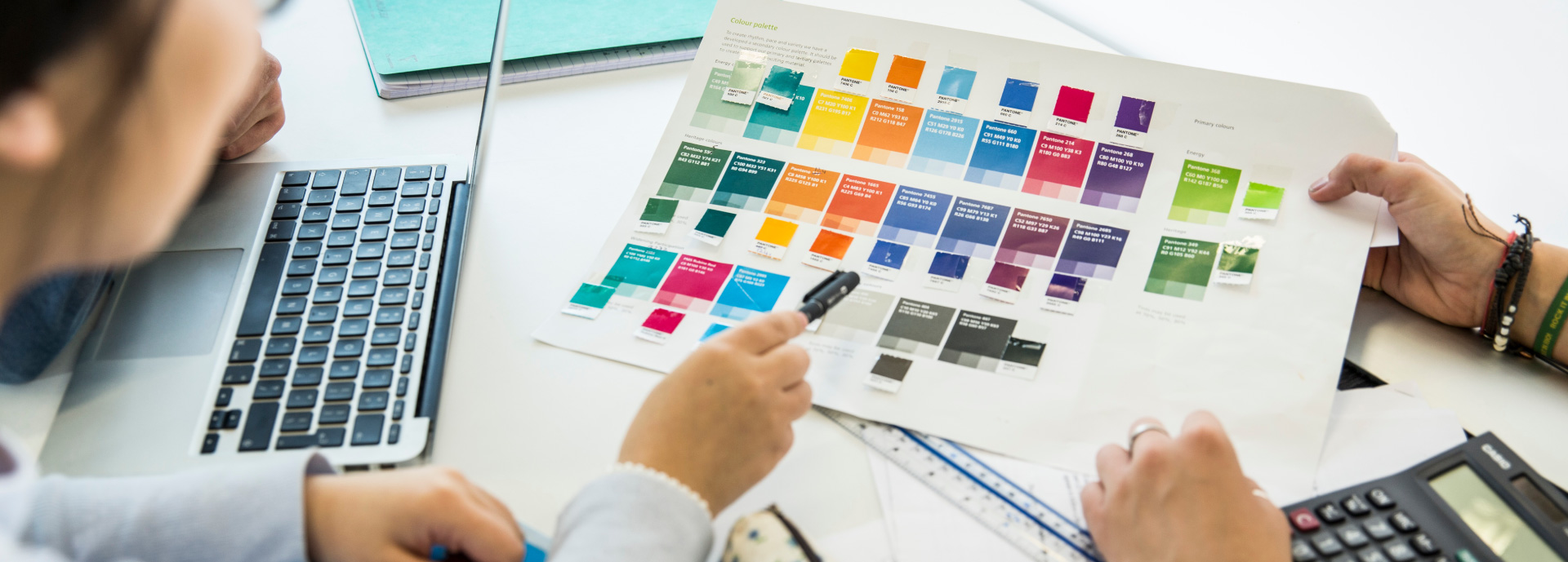 Two people looking at printed colour swatches