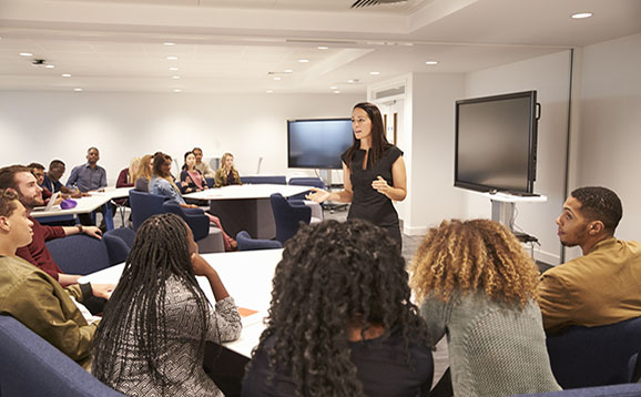 Female teacher addressing university students