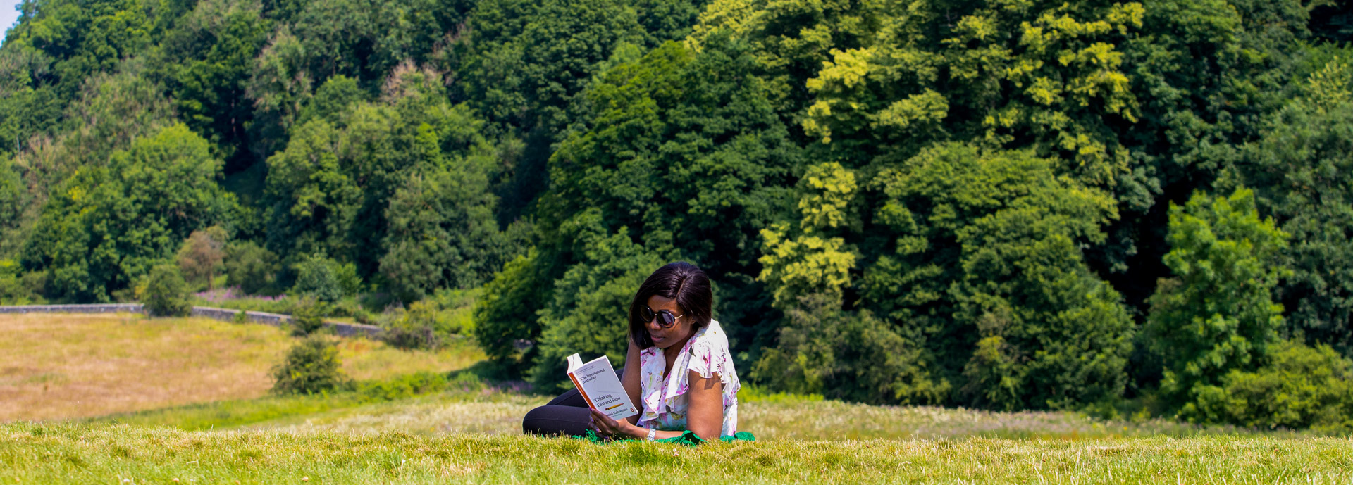 A student reading on a sunny day in Kings Knot, Stirling