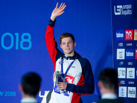 Duncan Scott waving on podium at European Championships