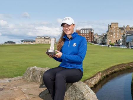 Hazel MacGarvie sitting on the Swilken Bridge with the St Rule Trophy at the Old Course, St Andrews