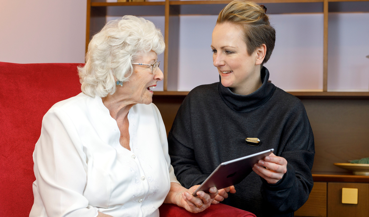 Lesley Palmer shows a dementia app to an elderly lady