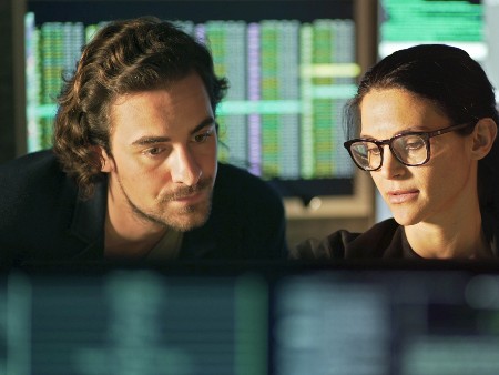 Stock shot of man and woman looking at data