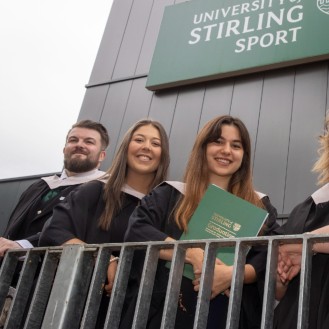 Graduates pose on the balcony of the Sports Centre