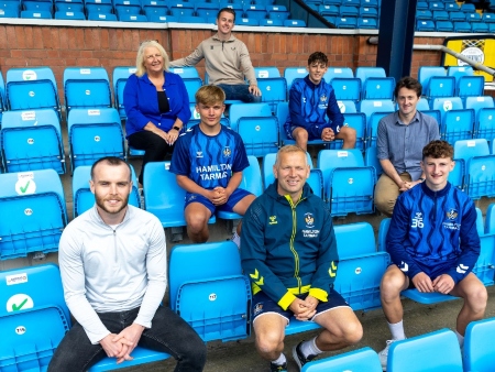 2.	From top, L to R: Wellbeing Coach Louis Kerr, Moira Greentree of Care Visions, Under-18s Kilmarnock players Josh and Logan, Allan Muirhead of Care Visions, Wellbeing Coach Louis Kerr and Kilmarnock Football Club’s Youth Ambassador, Charlie Adams., sitting in stands at Rugby Park