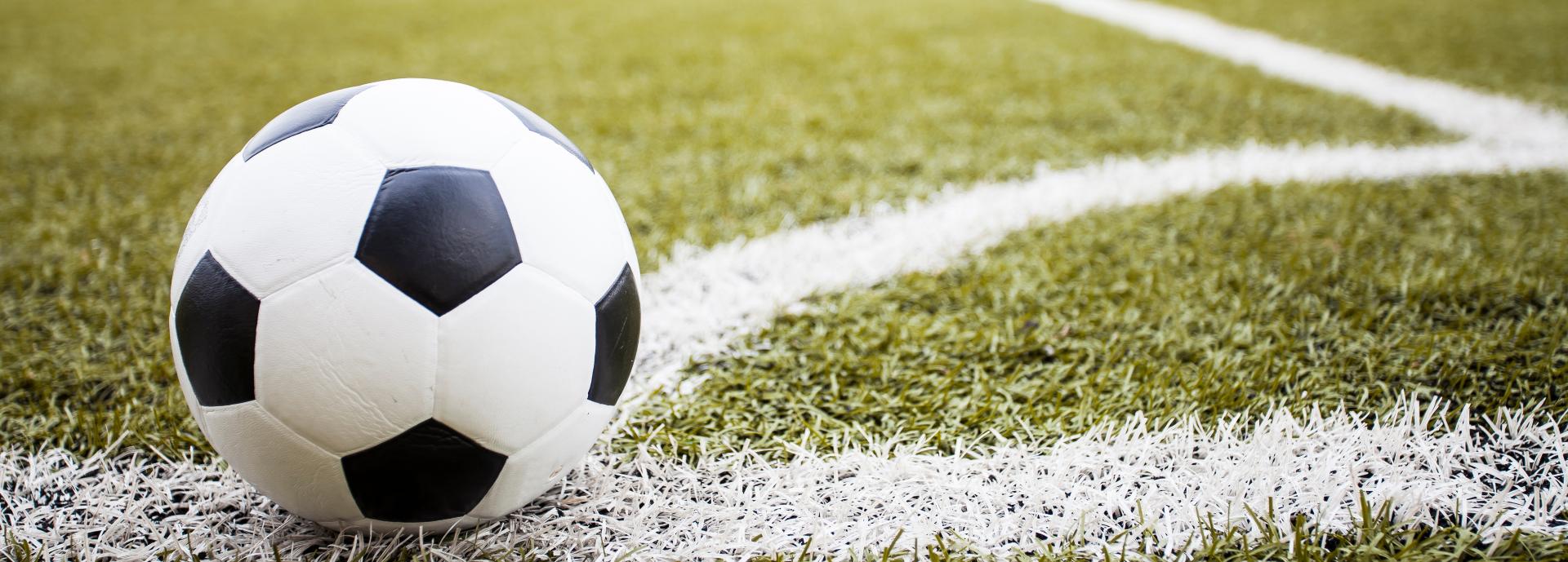 Stock image of a football on the corner line of a pitch