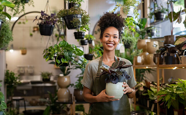 Small business owner smiling in her plant shop 760x470