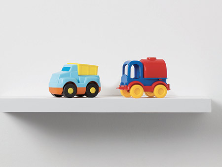 Toy cars on a shelf with a stark white background