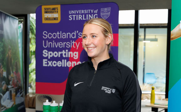 A cheerful student ambassador at a University of Stirling sport stall