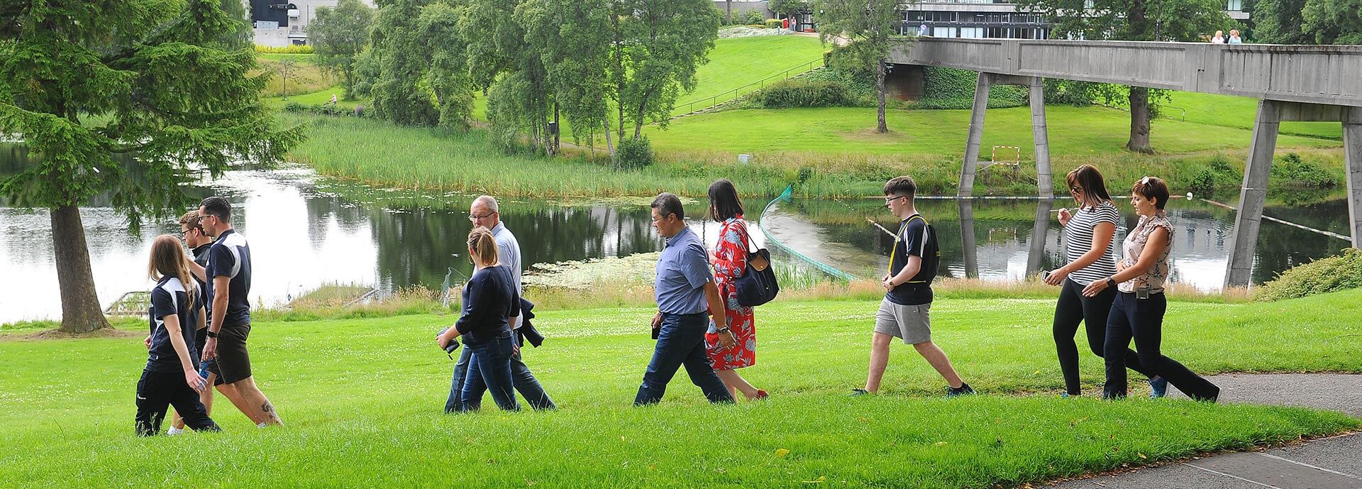 Group of people walking along by loch