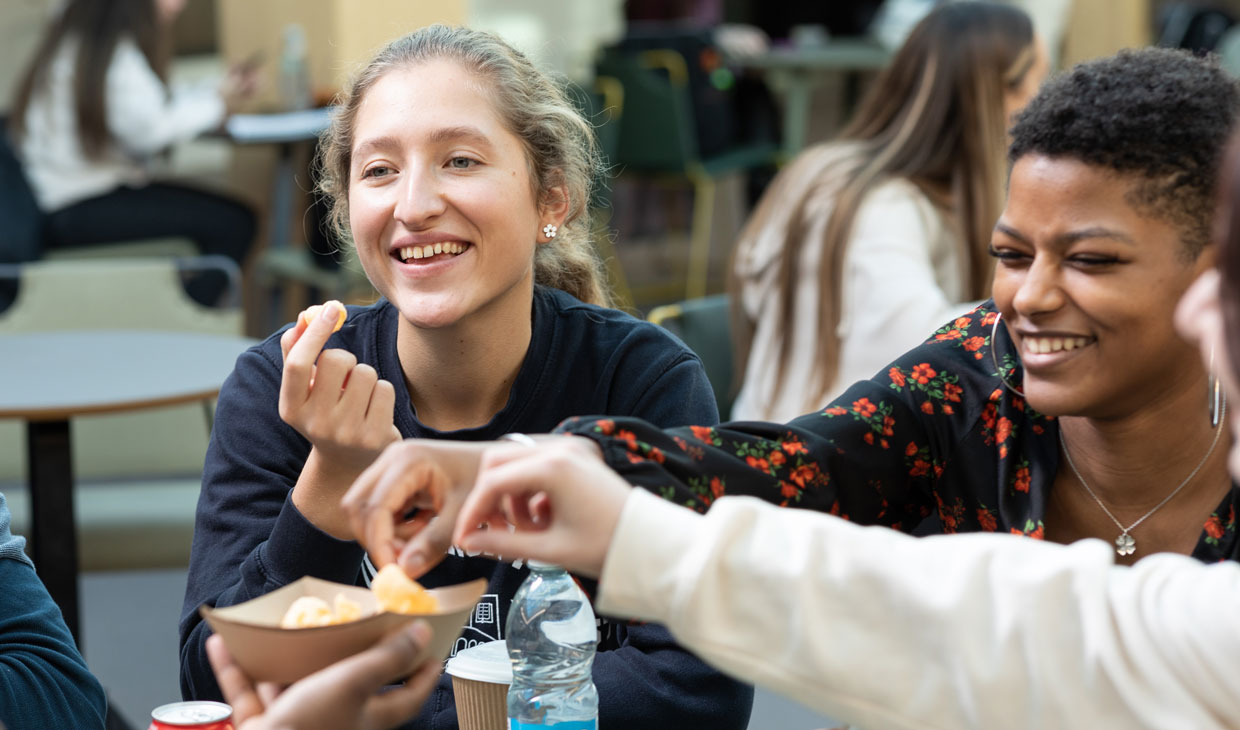 A group of students enjoying a plate of chips