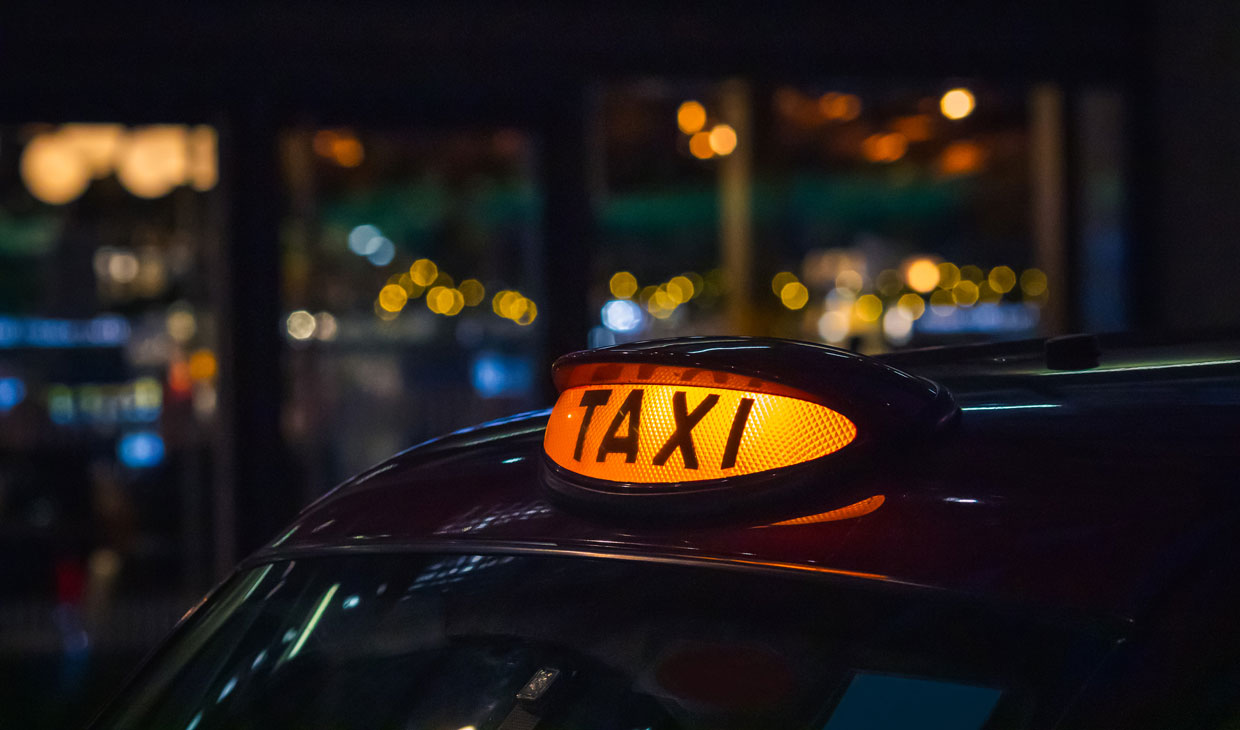 A lit-up taxi sign at night