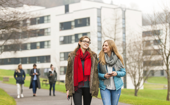 Two students walking on campus near the accommodation buildings