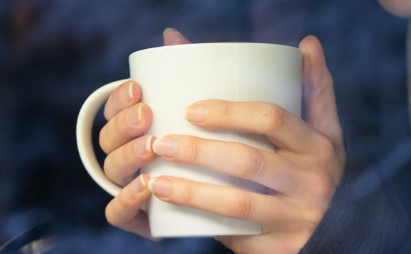 Hands clutching a cup of tea