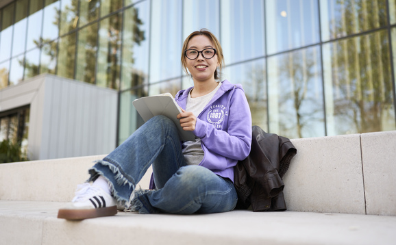 Student sitting outside the Sports Centre