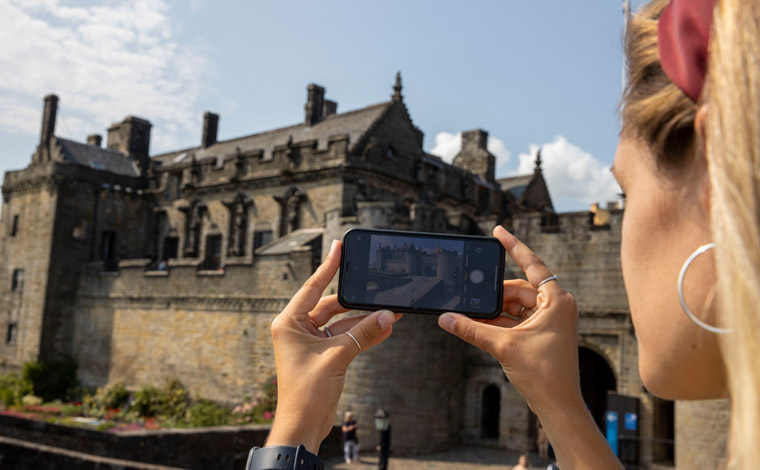 A student taking a picture of Stirling Castle on their cameraphone