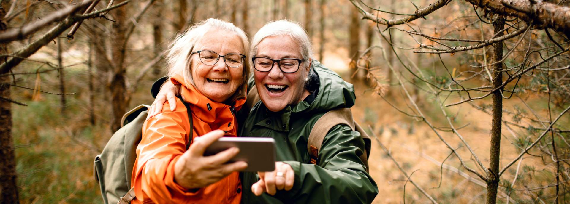 older women takins selfie in wood