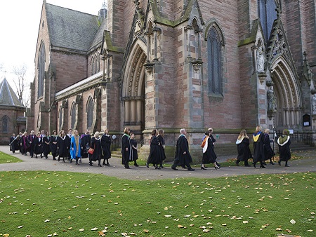 procession of people in graduate robes outside Inverness cathedral