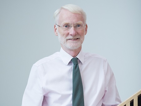 man with grey hair and beard in shirt and tie