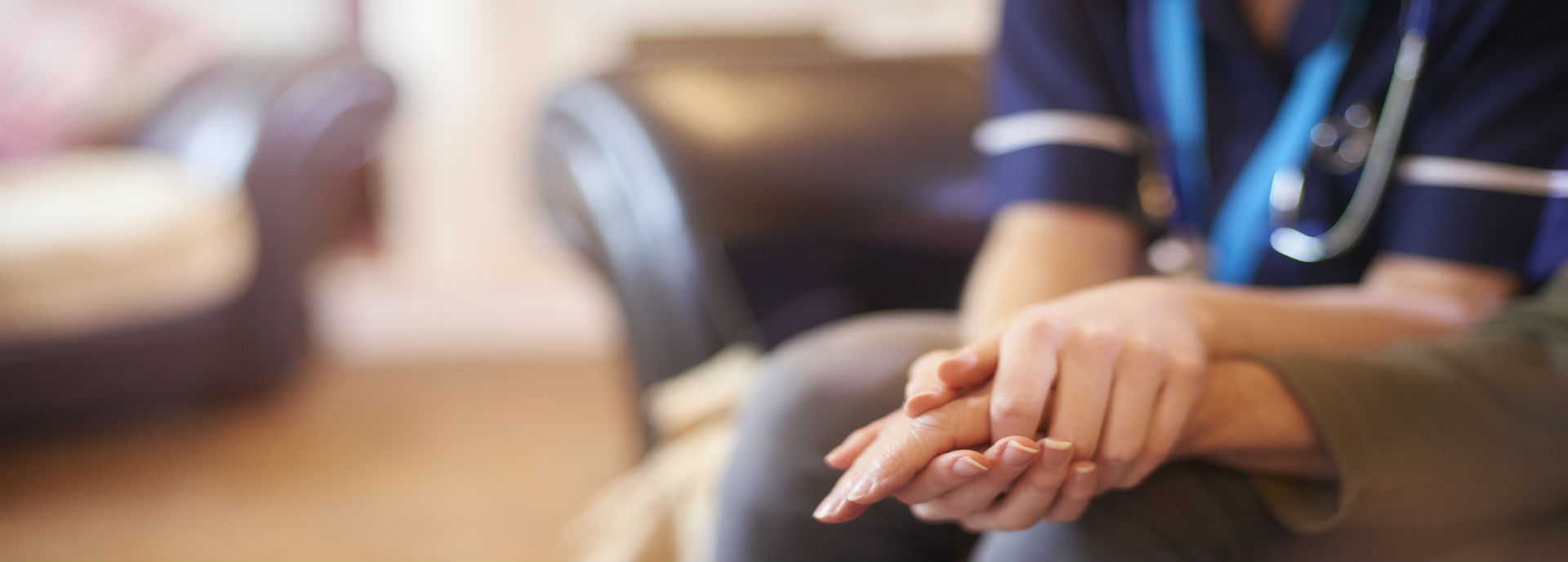 Closeup of a nurses hands holding another person's hand