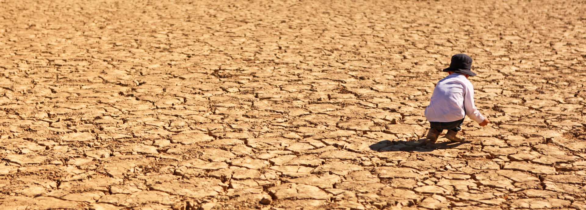 Child Playing on Dry Parched Desert Land stock photo