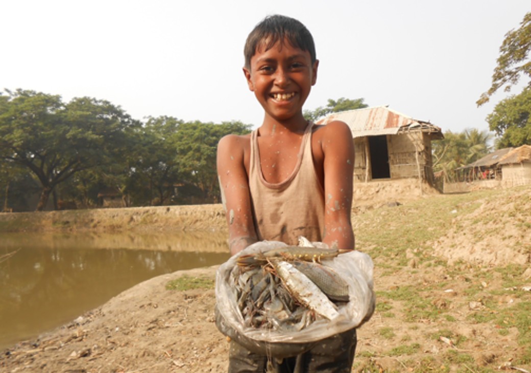 Boy holding a basket of fish in Bangladesh