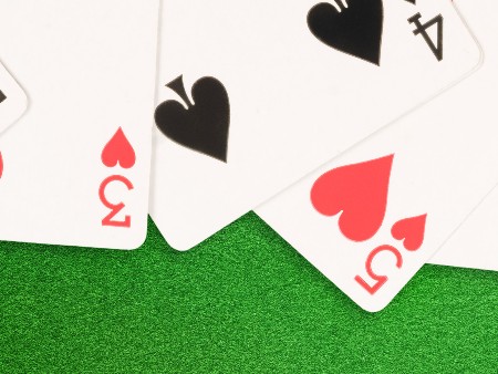 Playing cards spread out on a green felt background