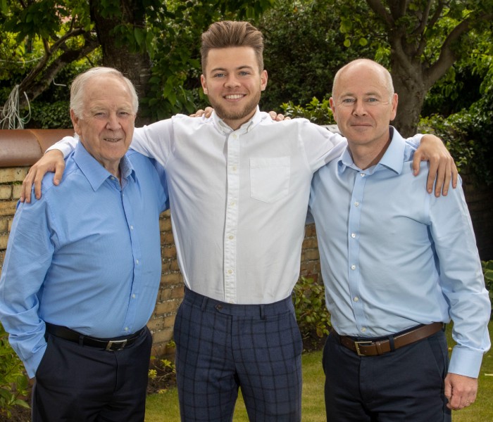 Craig Brown Jnr. stands with his arms round his grandfather and father, Hugh Brown
