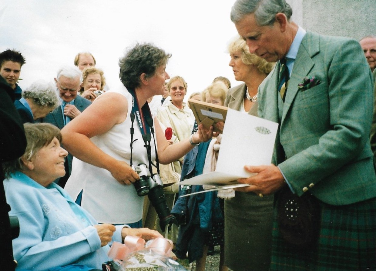 Sheila's mum (seated) and Sheila (with camera) with Prince Charles and Camilla