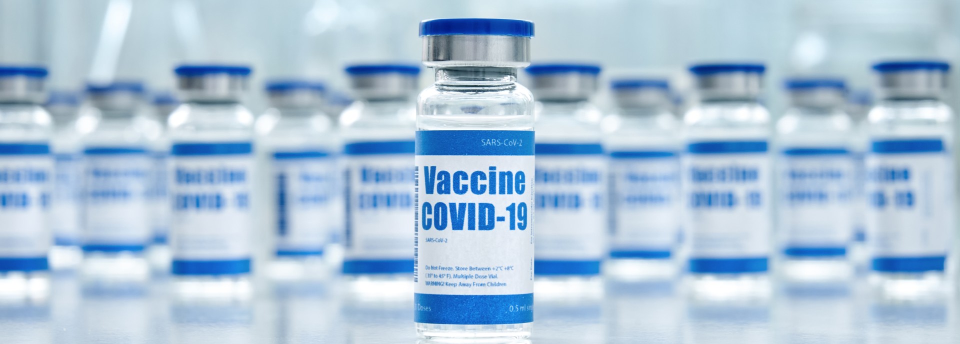 Vials of clear liquid marked with COVID-19 vaccine labels