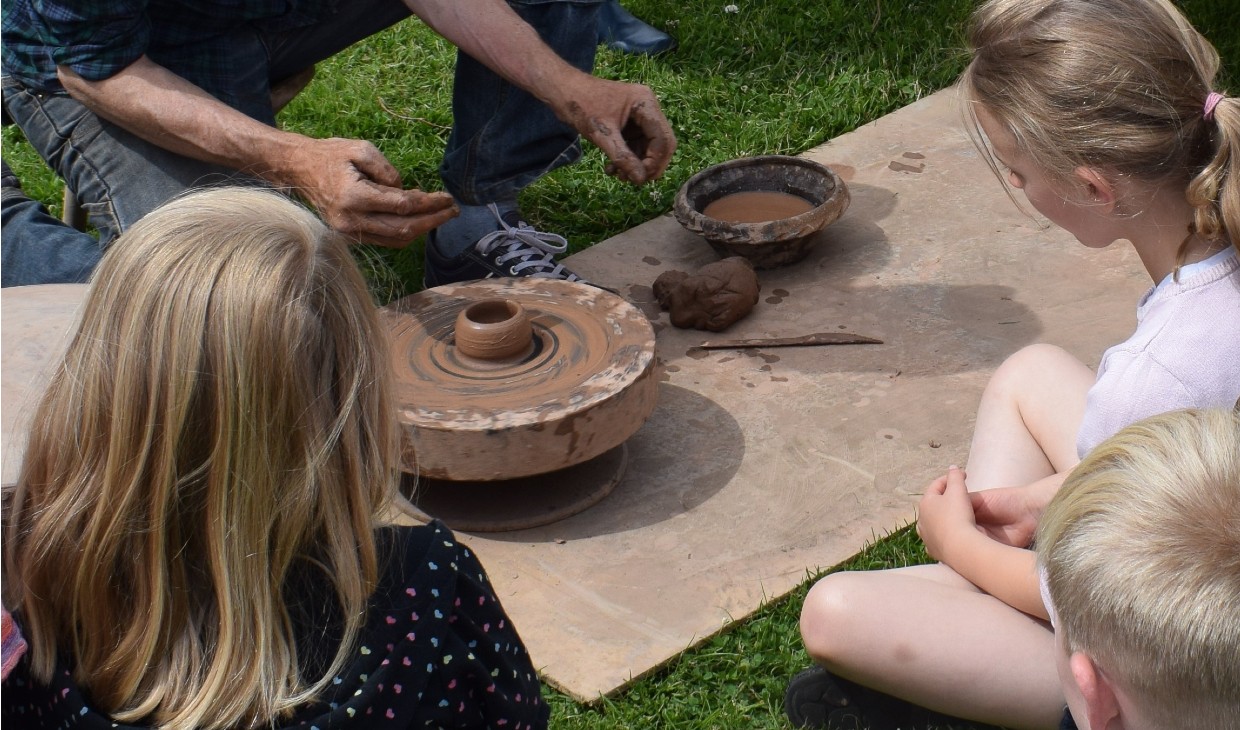 Children make clay pots at heritage museum