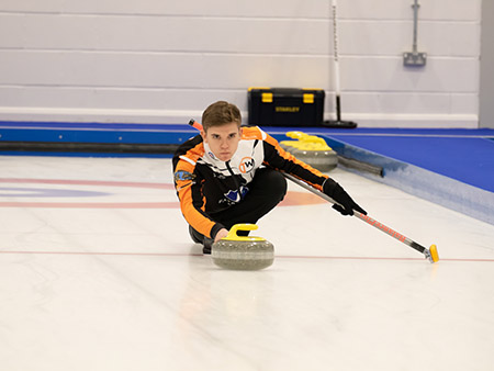 Ross Whyte pushing curling stone