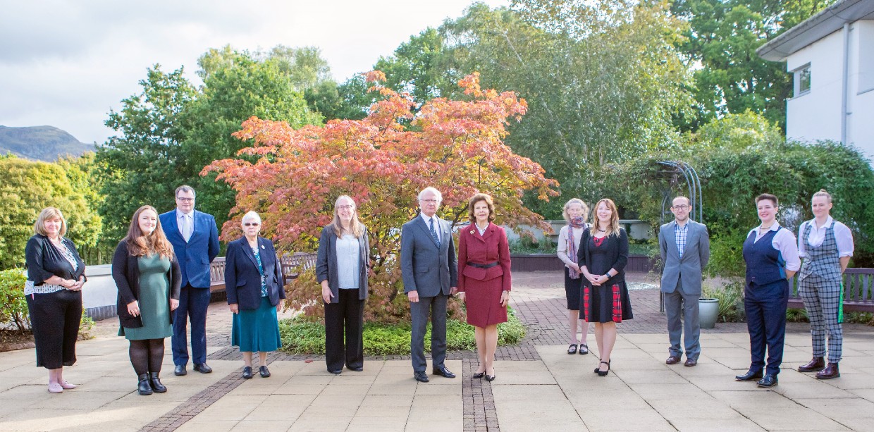 Researchers pose for photos in the garden with the King and Queen of Spain