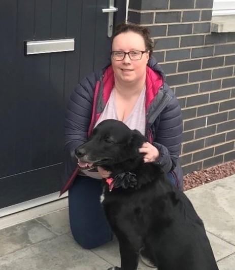 Sam photographed with her dog outside the front door of her home