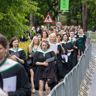 Graduates walking outside the sports centre after graduation