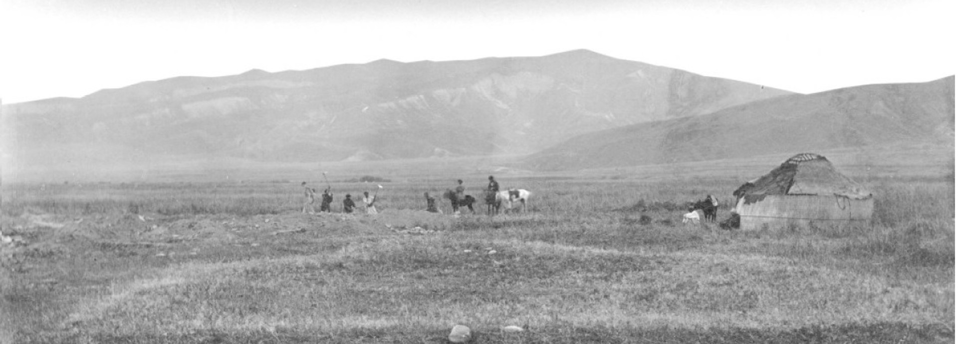 Historic photo taken during the original excavations in 1886. The image is black and white and shoes figures appearing to dig in the distance, and others  on horseback
