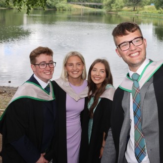 Group of graduates pose for selfie by loch