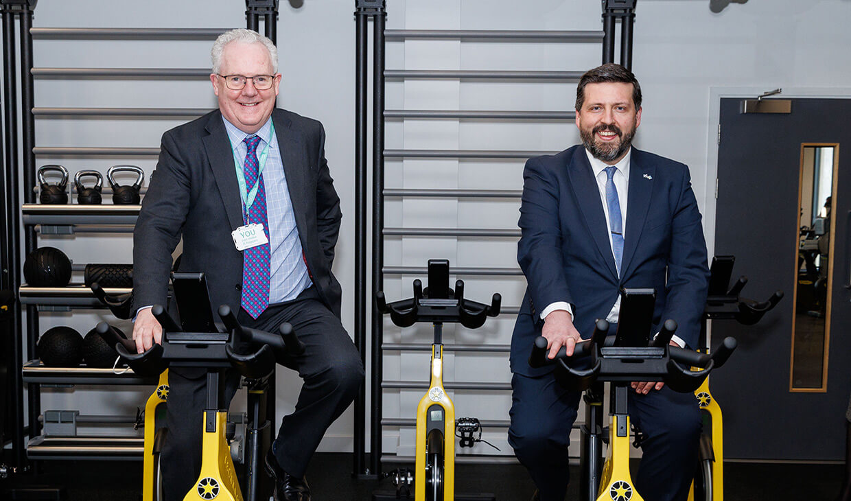 Principal and minister on exercise bikes
