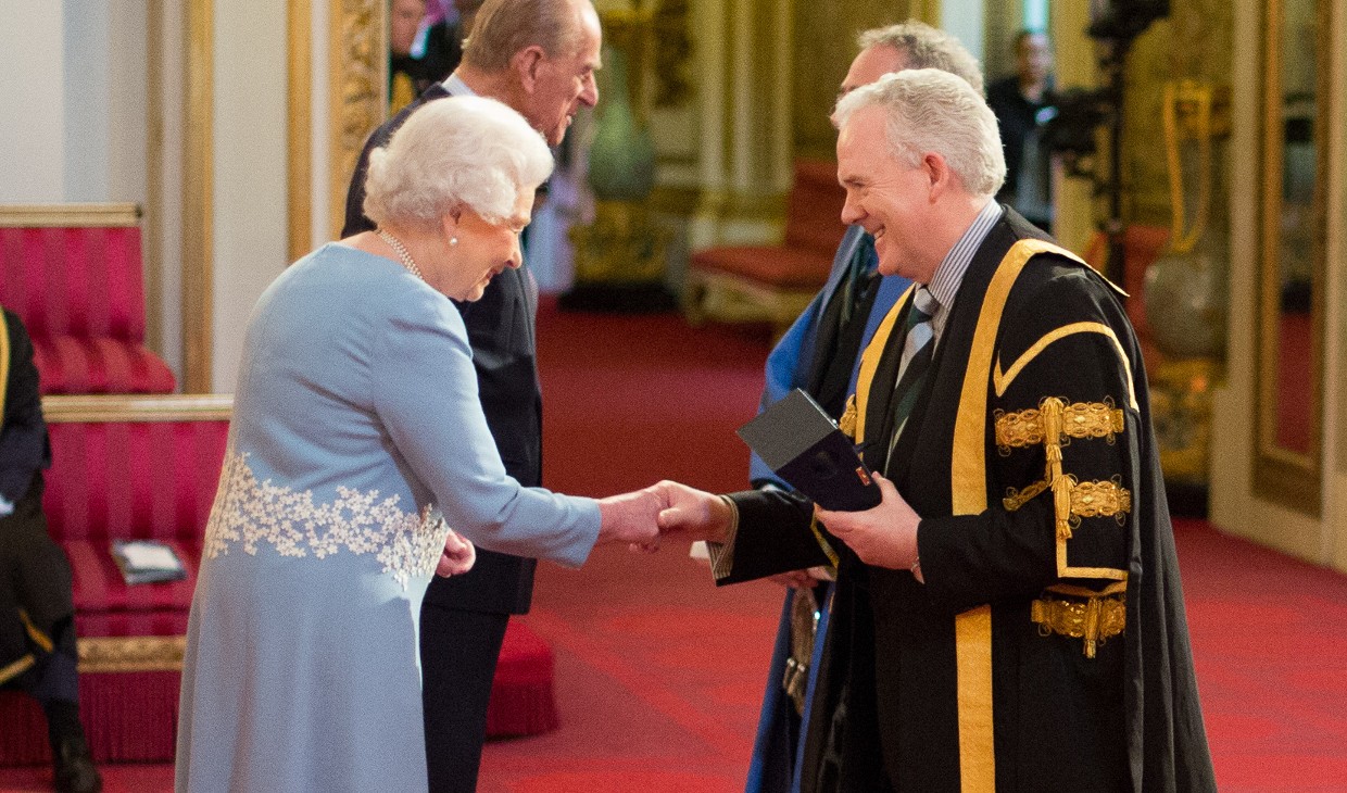 Professor Sir Gerry McCormac shakes the hand of Queen Elizabeth II at Buckingham Palace