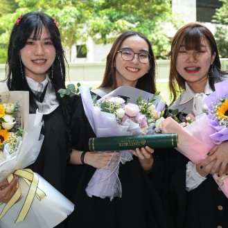 Singapore graduates holding flowers