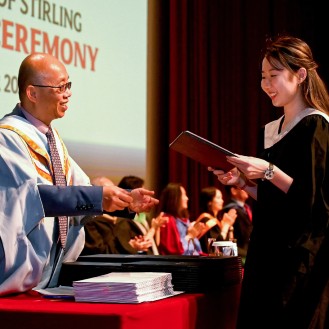 A Singapore graduate receiving their degree during the ceremony