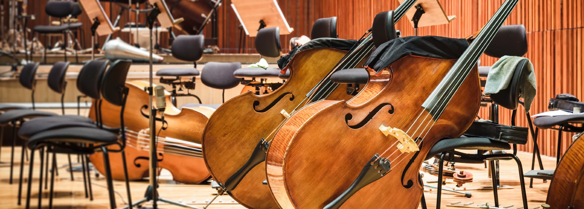 Orchestra instruments lean against seats in a performance hall