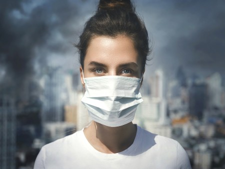 Woman wearing face mask amid air pollution