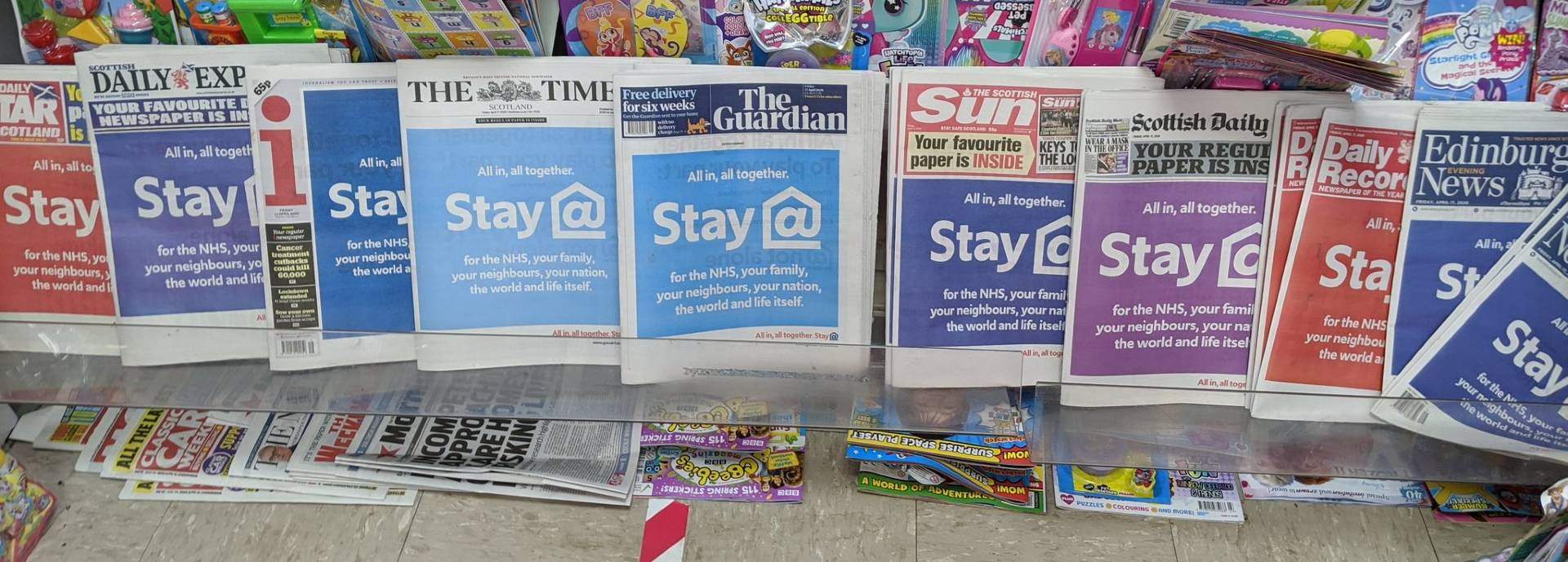 Newspaper shelves in a newsagents in May 2020 showing headlines including 'Stay Home!'