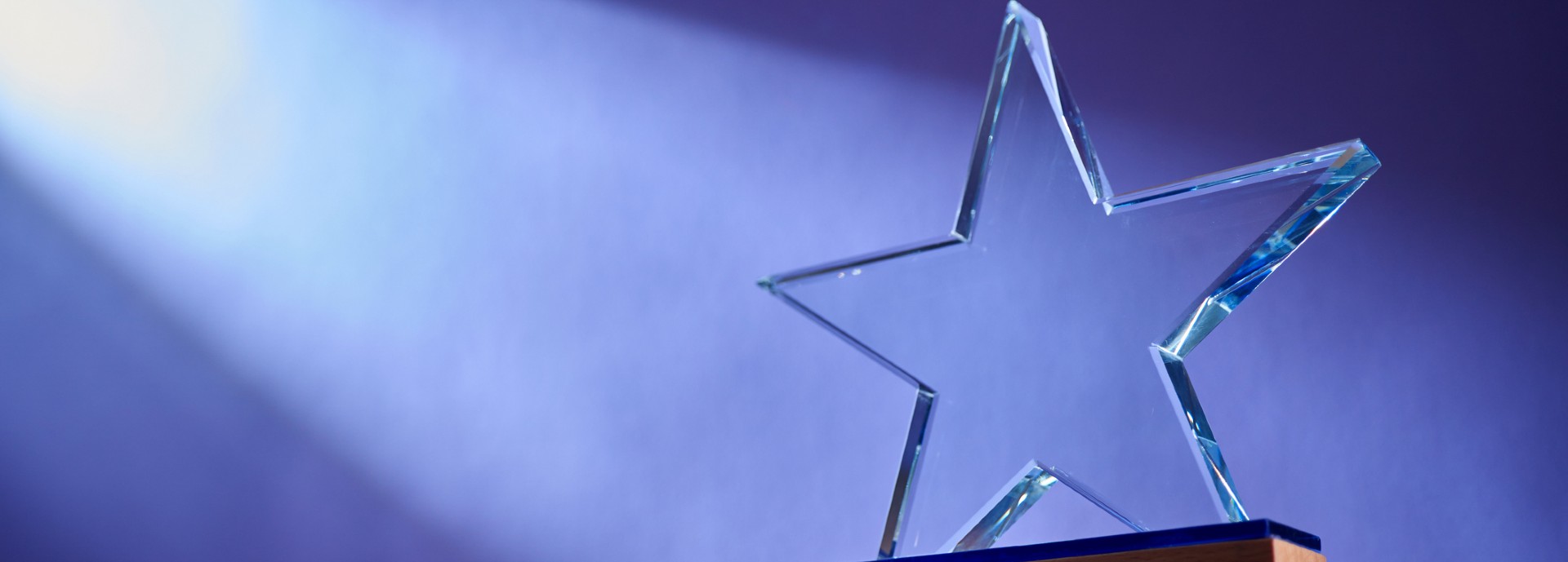 Star shape of crystal trophy against purple background