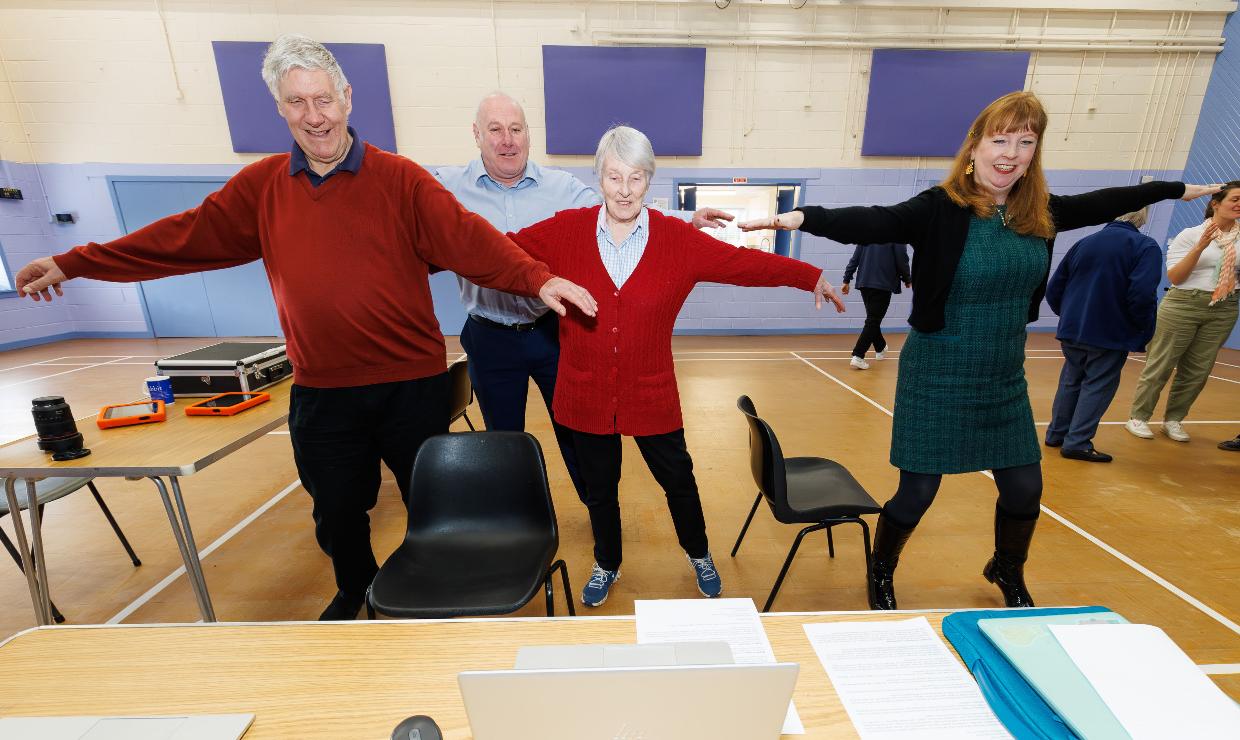 A group of older people take part in an online movement class