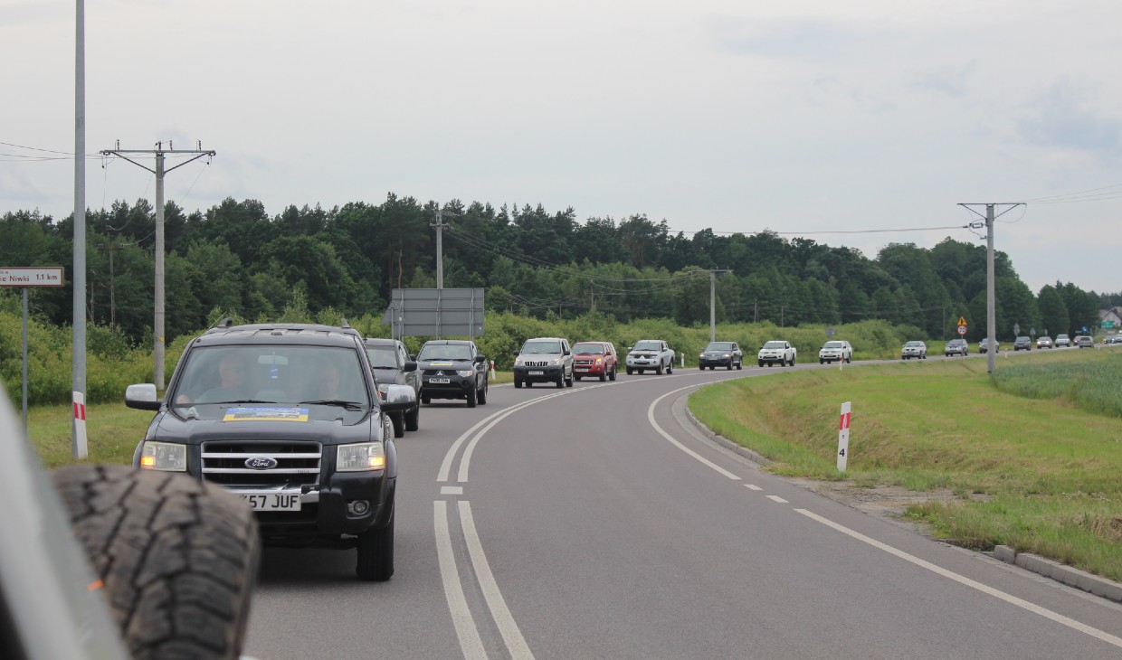 A long line of jeeps driving along a road