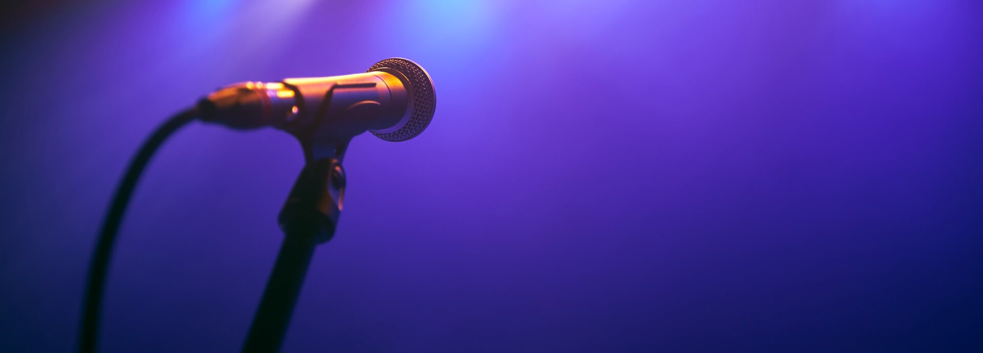 Selective focus on lluminated microphone on stage