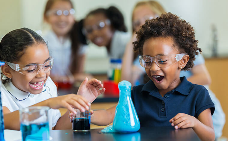 Children amazed at science experiment in classroom