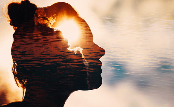 Silhouette of person's head and sunrise